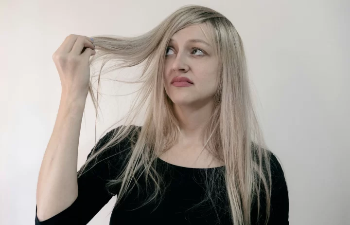 Wanita dengan rambut lepek dan akar rambut terlihat.